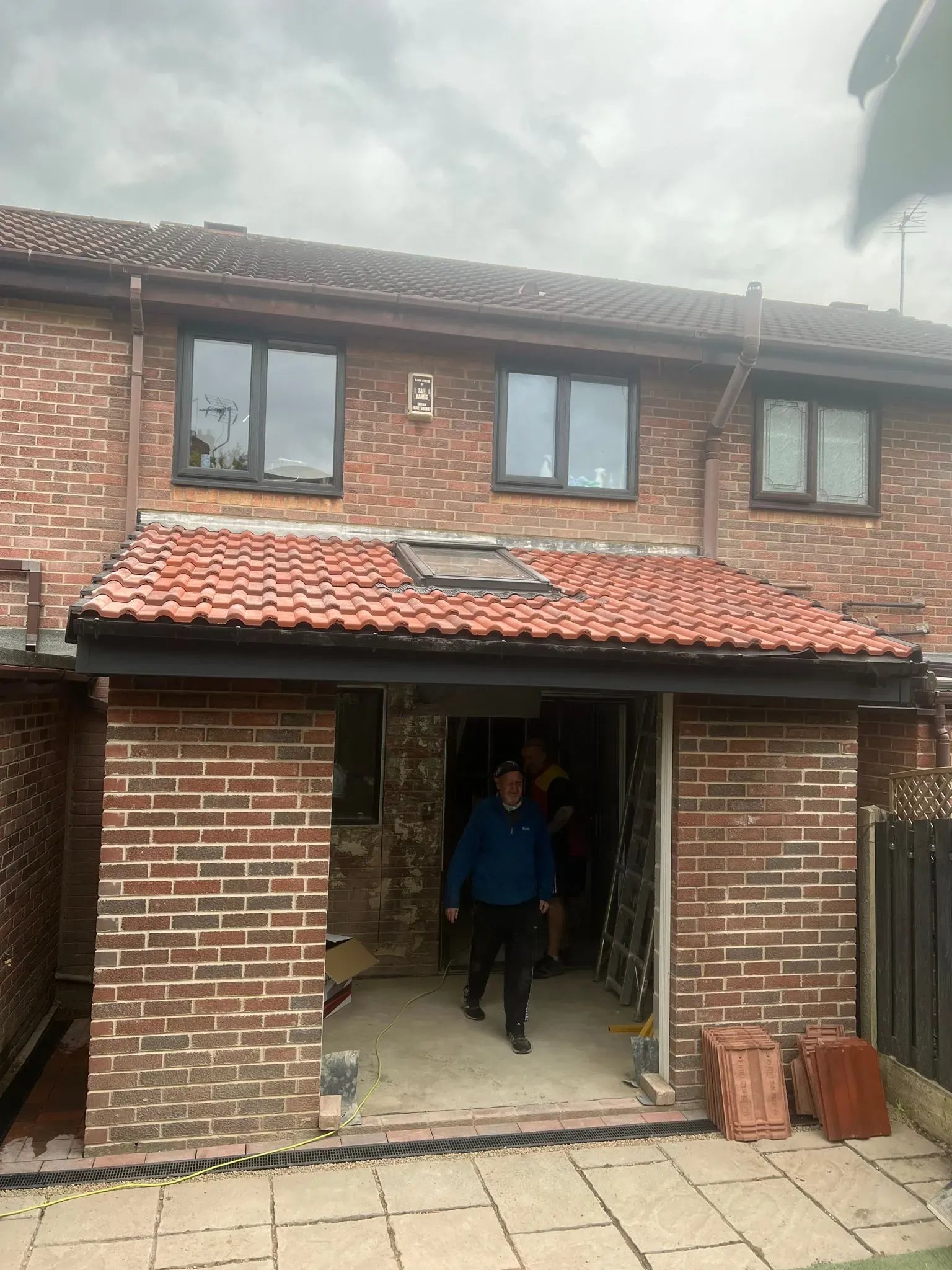 Roofers installing a new tiled roof on a house extension in the Sheffield or Peak District area.