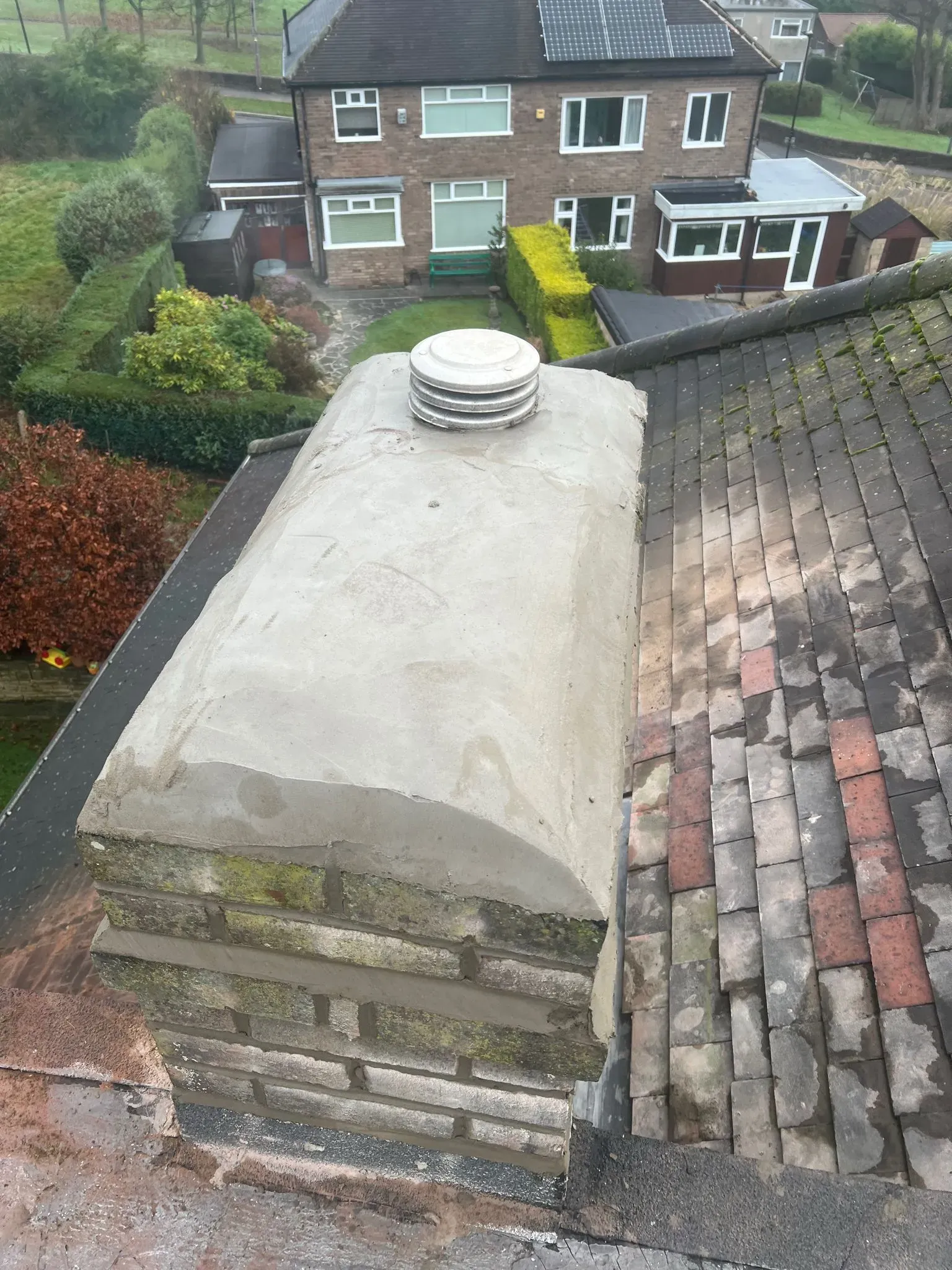 Brick chimney stack on a residential tiled roof