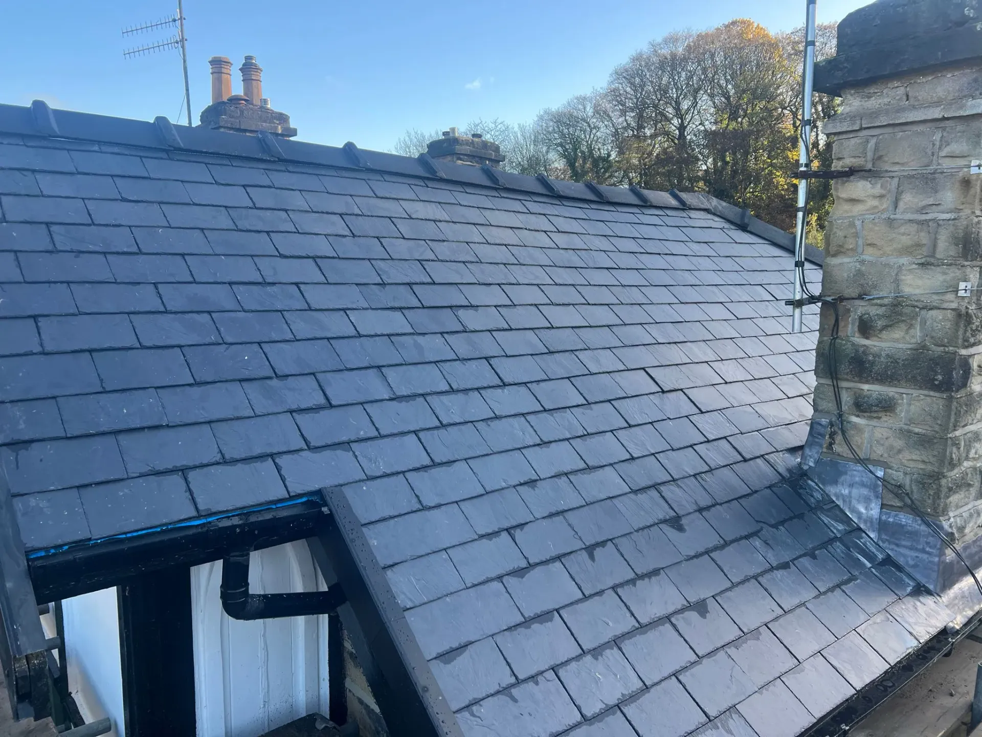 Slate pitched roof with chimney and lead flashing