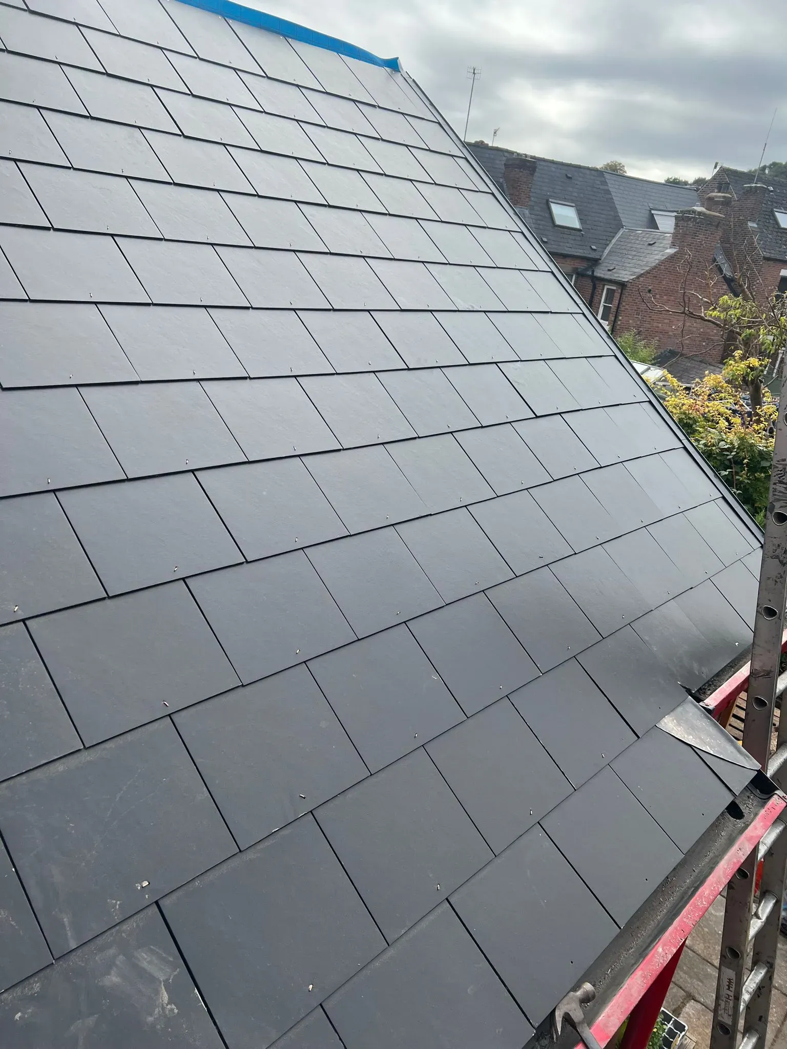 New pitched roof installation with dark grey tiles or slates in Sheffield or the Peak District.