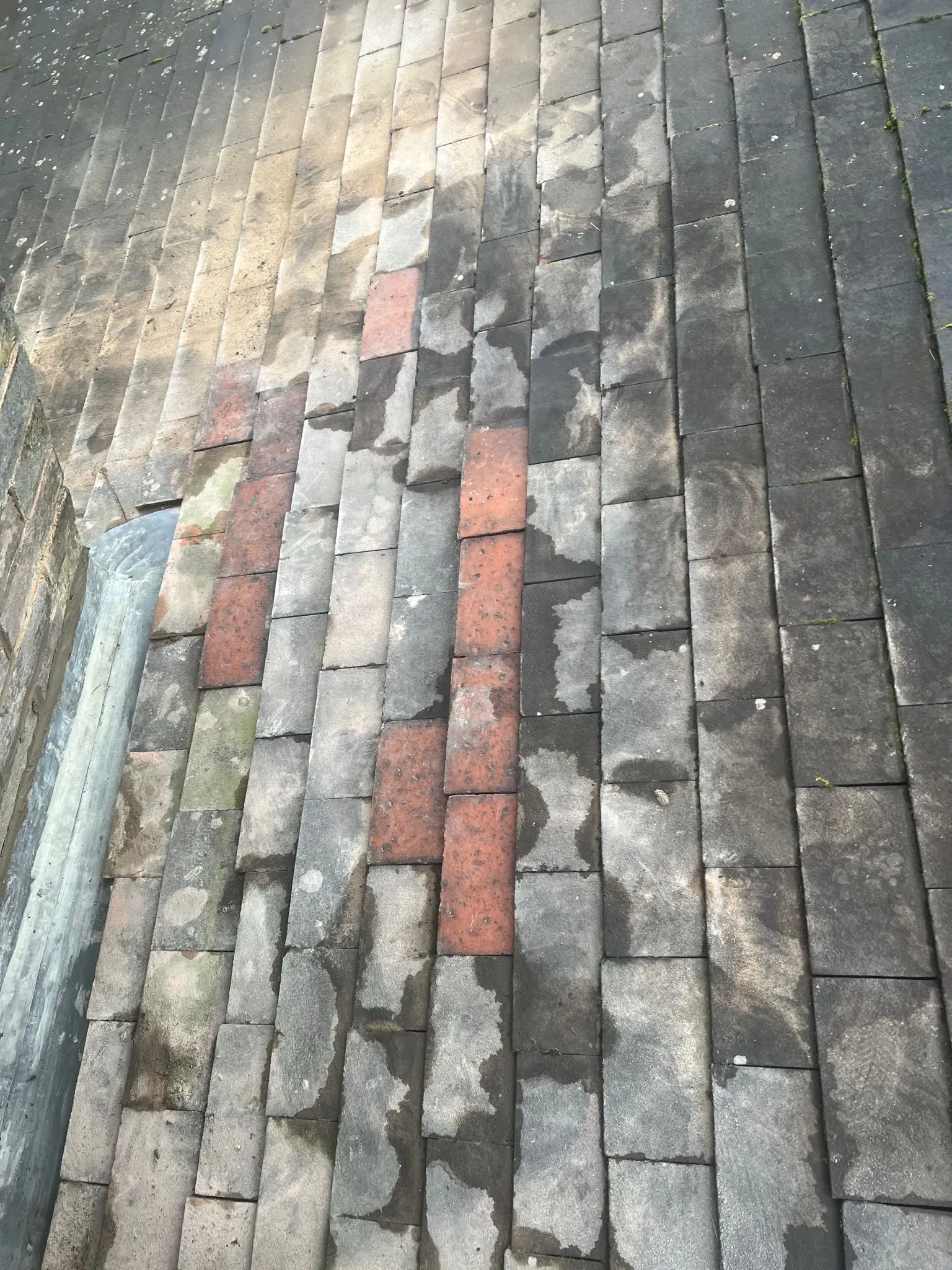 Close up of pitched roof tiles with leadwork
