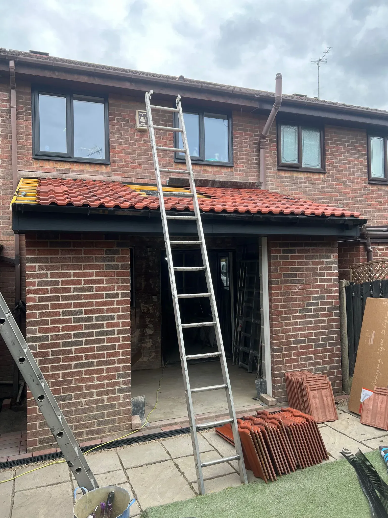 Installing roof tiles on a home extension.
