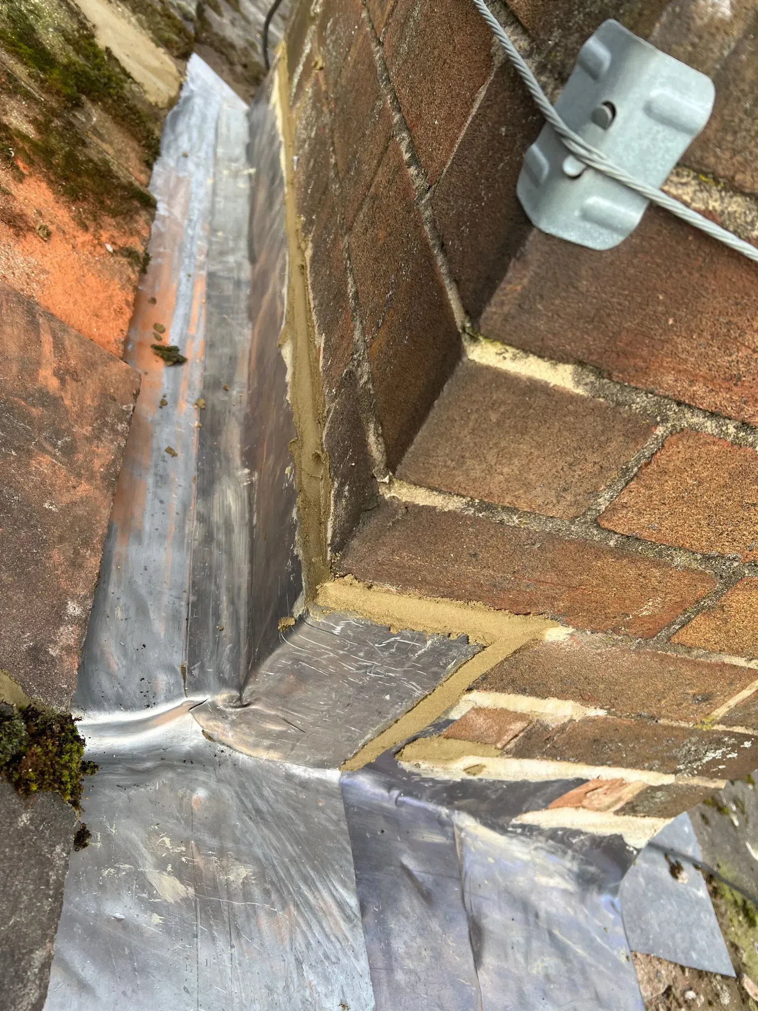 Lead flashing on a roof around a chimney.