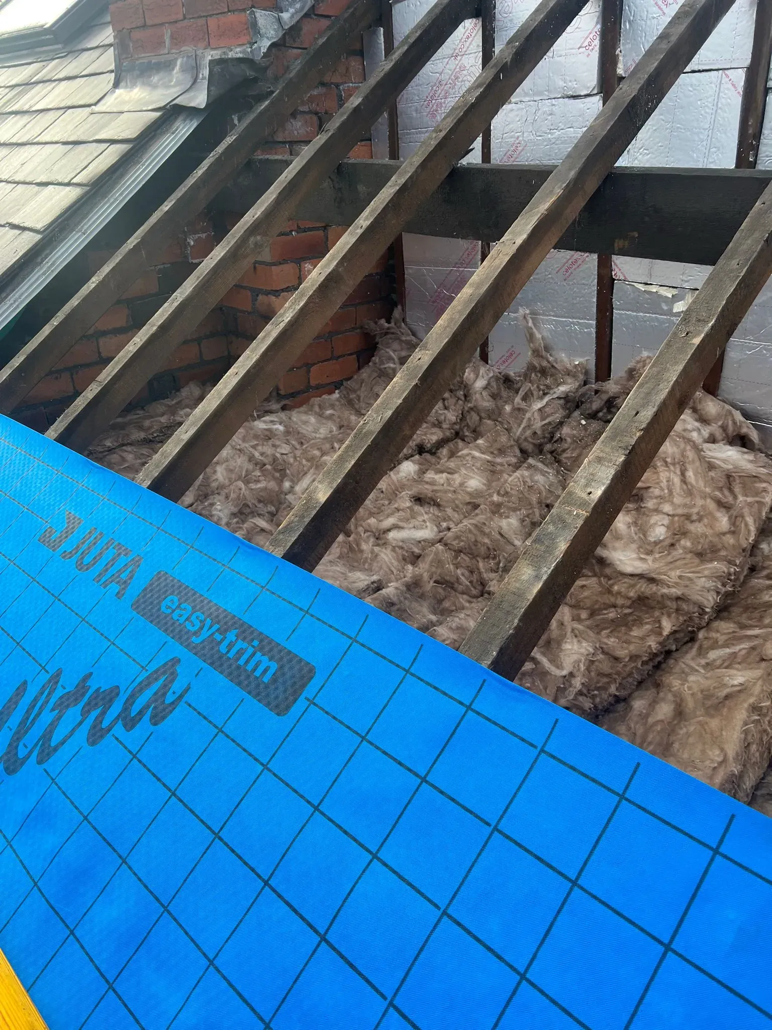 Roof structure with rafters, insulation, and underlay during roofing work by Alliance Roofing Services in Sheffield or the Peak District.