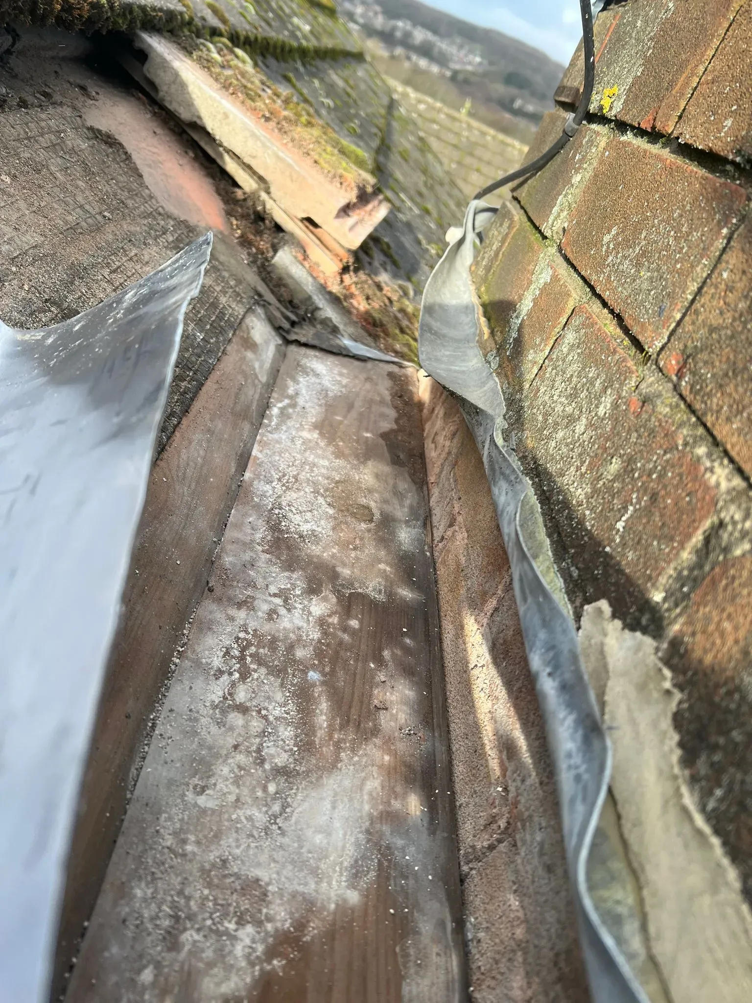 Close-up of a roof valley with lead flashing and tiles