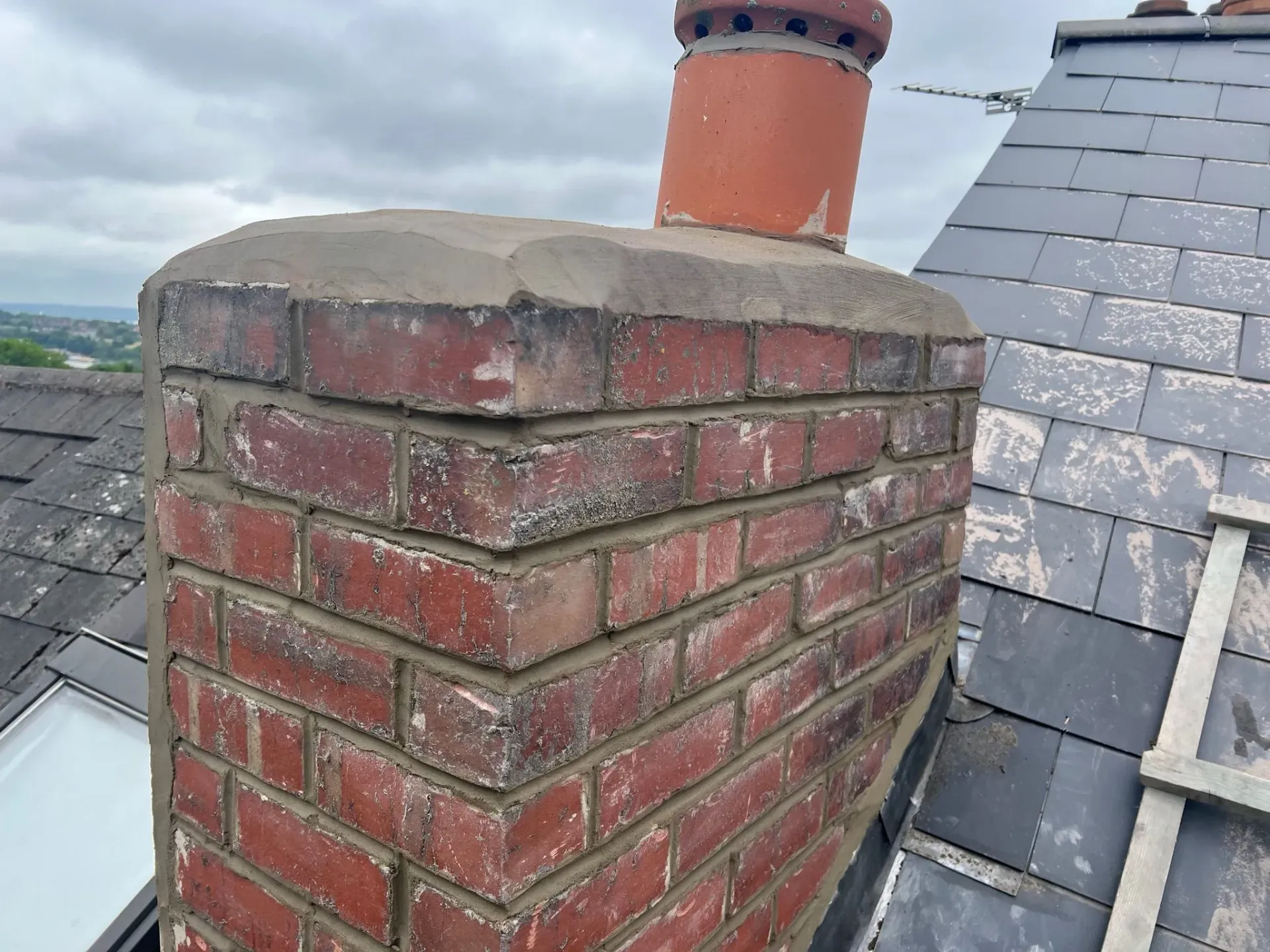 Brick chimney on roof with repaired mortar and rendering in Sheffield
