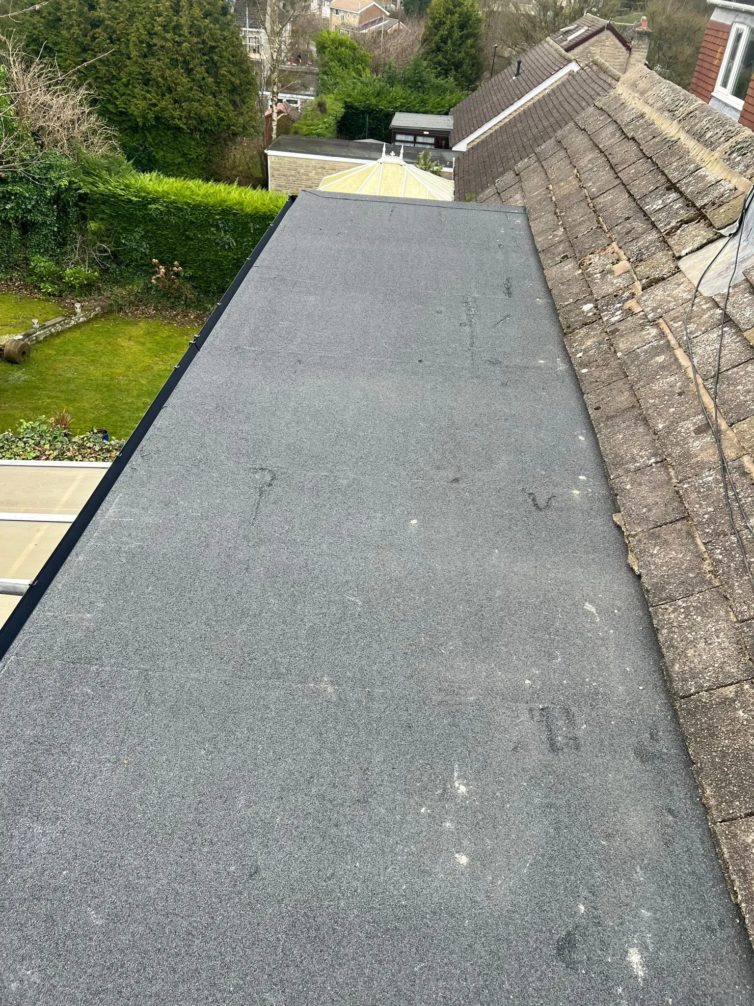 Flat roof adjoining a tiled pitched roof