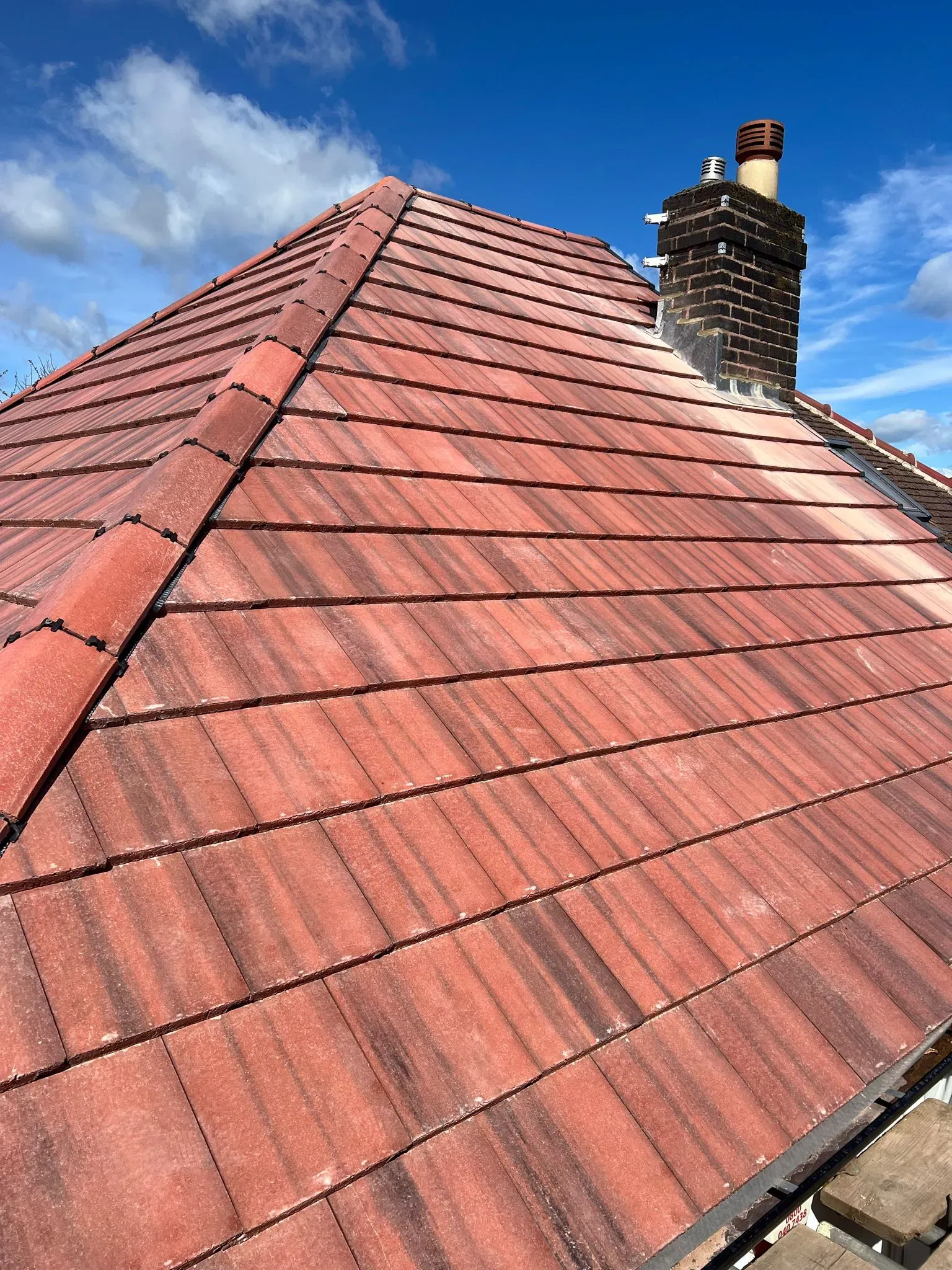 Red tiled pitched roof with chimney and dry ridge system