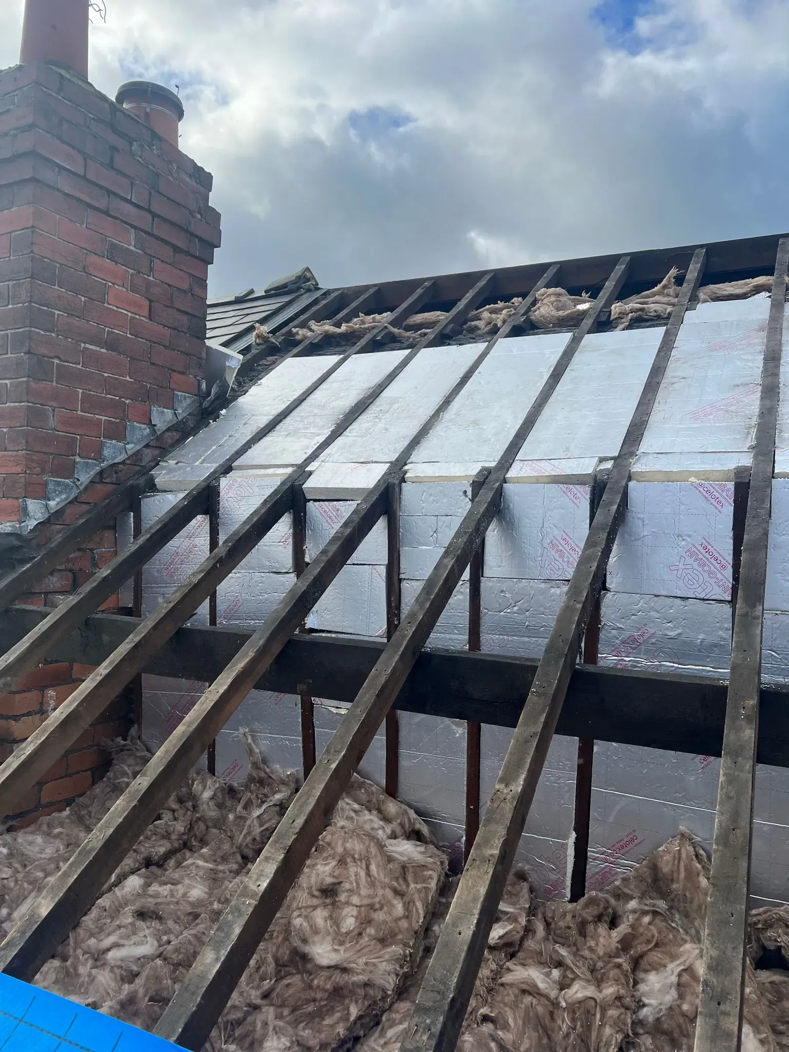 Pitched roof structure with new insulation installation next to a chimney in Sheffield