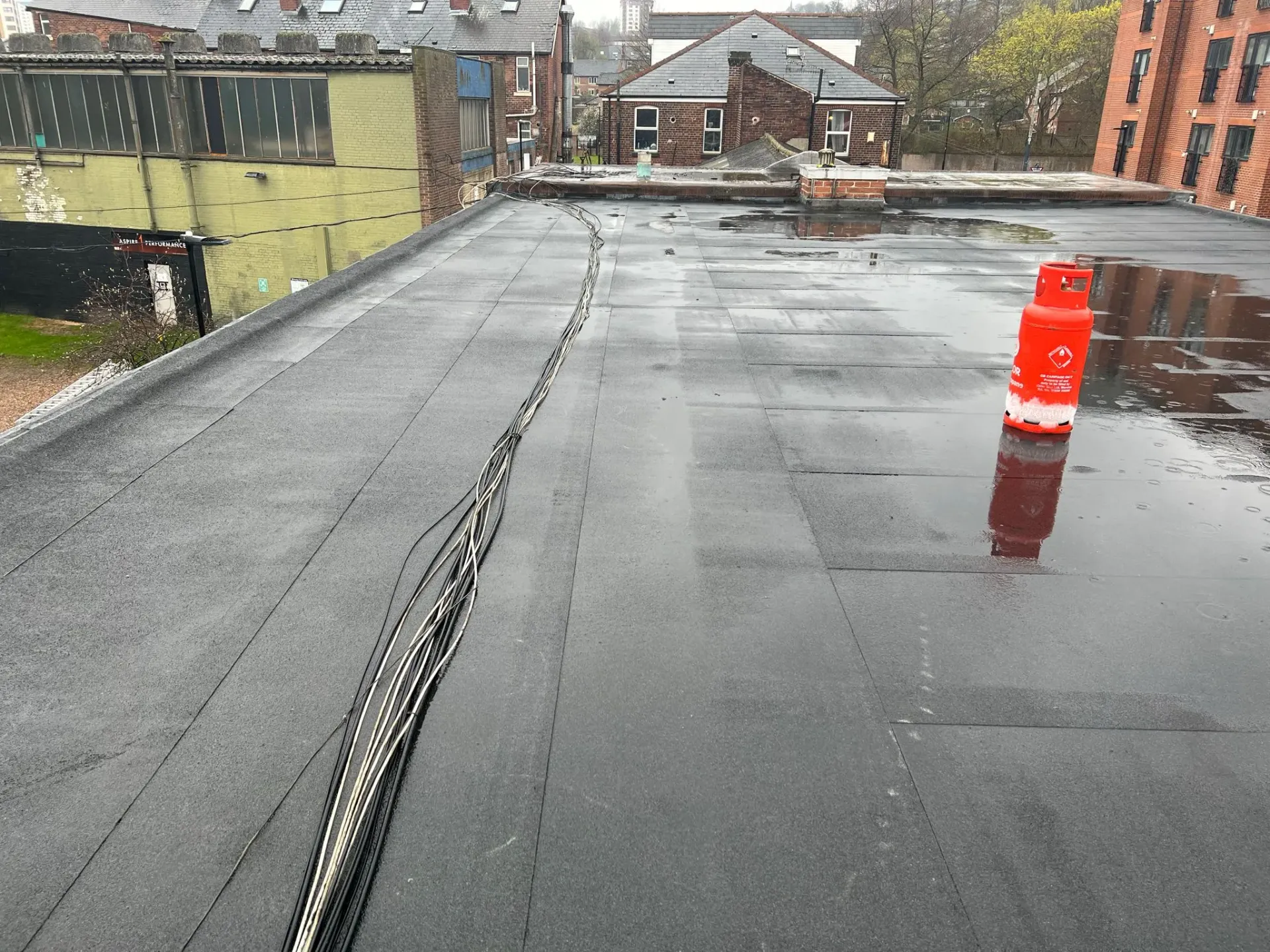 Flat roof with water, cables, and gas bottle.