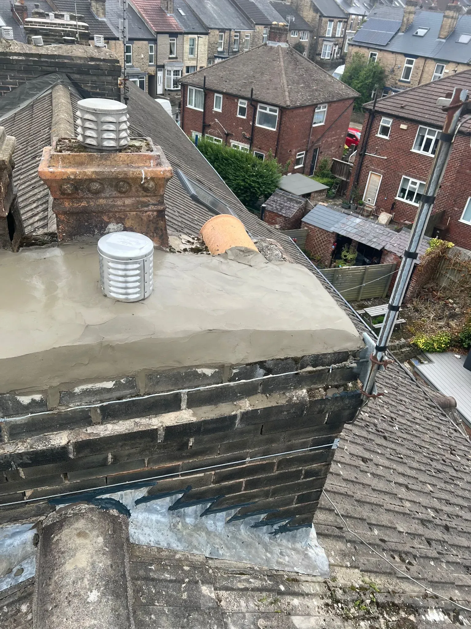 Photo showing recent repair work on a chimney on a house roof